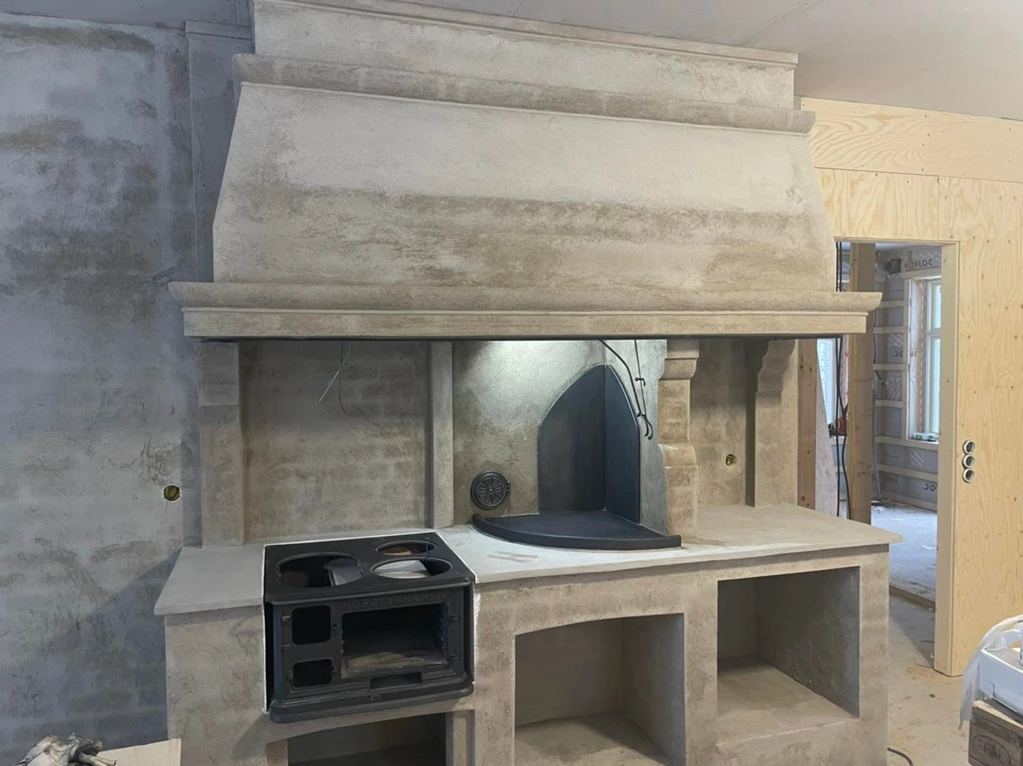 Handgjuten köksmiljö i betong med vedspis